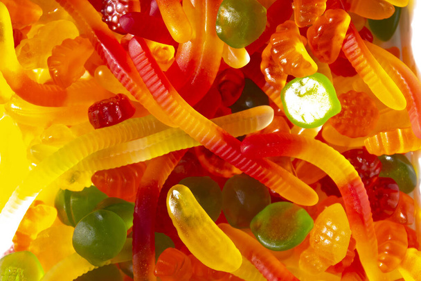 Closeup view of assorted colorful different shape jelly candies. Gummy worms and colorful jelly beans - Fotoğraf, Görsel