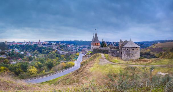 Panoramisch uitzicht op de nacht van de oude vesting kasteel in Kamianets-Podilskyi, Khmelnytskyi regio, Oekraïne. Oude kasteelfoto op een ansichtkaart of omslag. Lange uiteenzetting - Foto, afbeelding