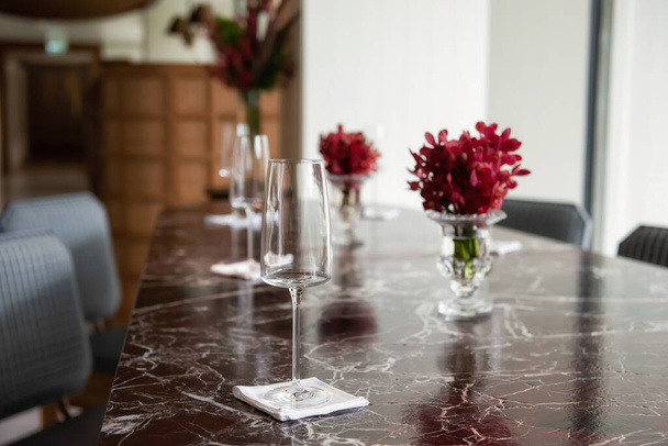 Brýle a červený květ stolu. krásné prostředí v luxusní hotelové restauraci pro pití vína nebo šampaňského u oběda. - Fotografie, Obrázek