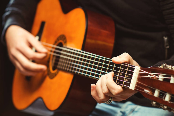 Hands of man playing guitar. Guitarist holding an acoustic guitar. Handsome man playing guitar at the pub. Hipster guy playing guitar. Music concept. Music festival. - Photo, image
