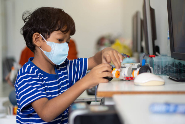 Asiatico ragazzo indossare maschere per prevenire il Coronavirus 2019 (COVID-19) nelle scuole. - Foto, immagini