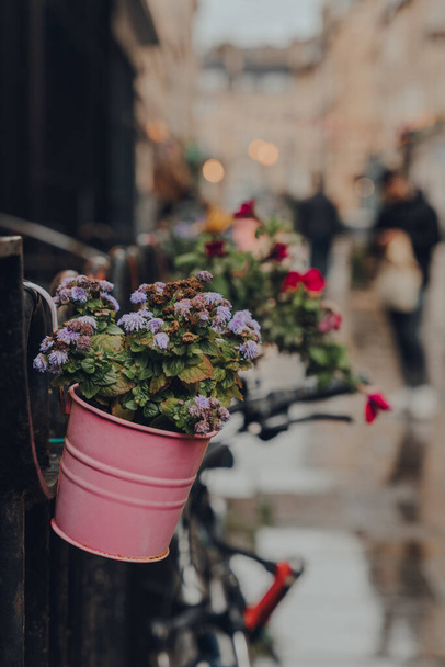 Paniers à fleurs dans une rue à Bath, Somerset, Royaume-Uni, mise au point sélective, personnes non identifiées sur le fond. - Photo, image
