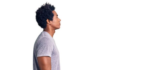 Jóképű afro-amerikai férfi afro haj visel alkalmi ruhák keres oldalra, pihenni profil pózol természetes arc magabiztos mosollyal.  - Fotó, kép