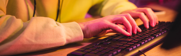 Cropped view of gamer using computer keyboard at table, banner  - Foto, imagen