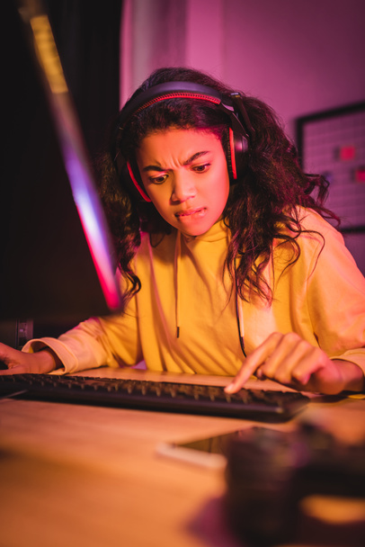 Напружений афроамериканський геймер використовує комп'ютерну клавіатуру під час гри у відеоігри
  - Фото, зображення