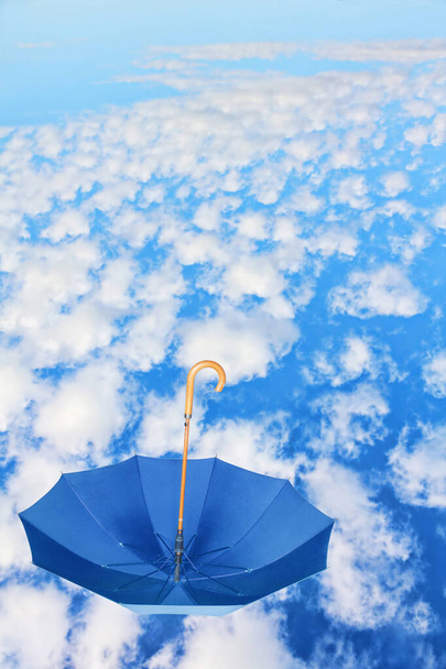 Fipped over blue umbrella flies in sky against of white clouds.Mary Poppins Deštník.Wind of change concept. - Fotografie, Obrázek