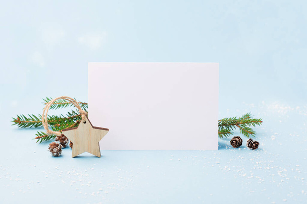 クリスマスや新年の冬の休日カード。クリスマスは環境に優しい概念を無駄にしない。お祭りのクリスマスの装飾、青い背景にモミの枝。選択フォーカス、コピースペース. - 写真・画像