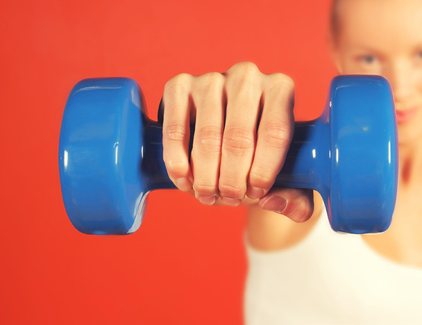 Closeup photo of a hand holding a blue dumbbell - Photo, Image