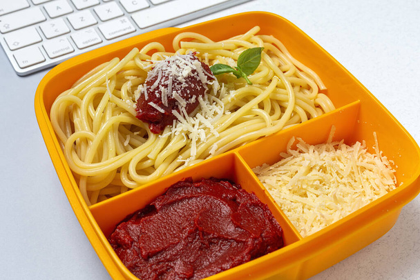 Healthy Food in Plastic containers ready to eat with homemade spaghetti with tomato, cheese and basil on the work table. Italian food. To take away. - Photo, Image