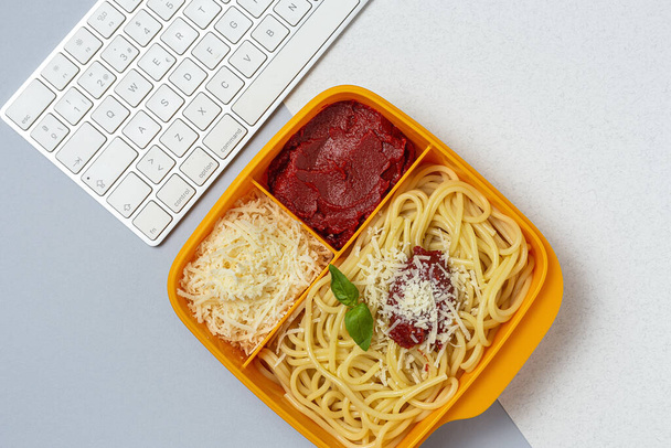 Healthy Food in Plastic containers ready to eat with homemade spaghetti with tomato, cheese and basil on the work table. Italian food. To take away. - Photo, Image