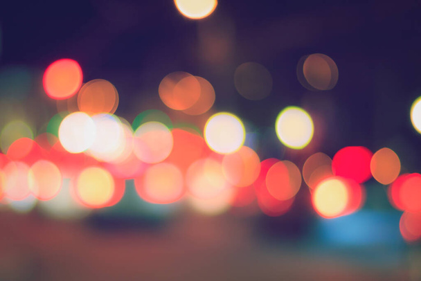 Verschwommenes Licht der Scheinwerfer von Autos und Laternen in der nächtlichen Stadt. Abstraktes helles Bokeh. - Foto, Bild