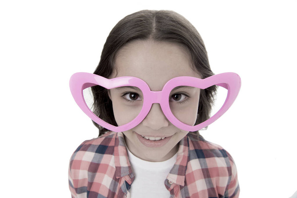 Love from first sight. Kid happy lovely feels sympathy. Kid girl heart shaped eyeglasses. Girl adorable smiling face in love. Child charming smile isolated white background. First love concept - Foto, imagen