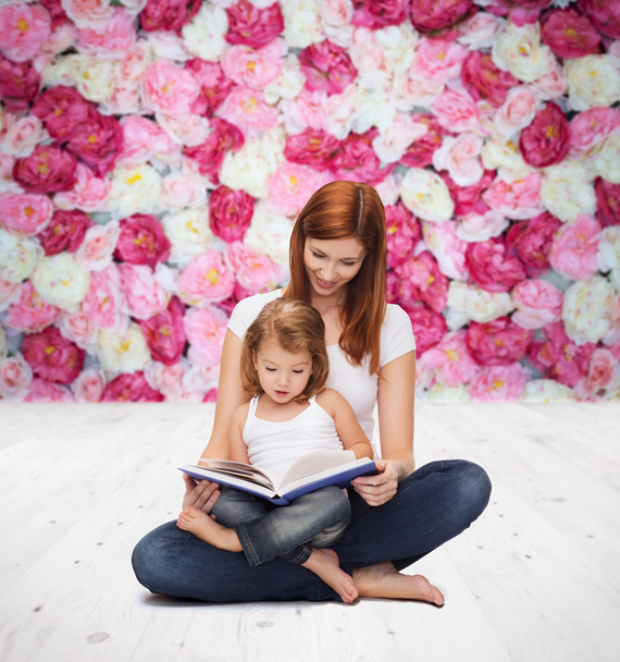 Happy mother with adorable little girl and book - Fotó, kép