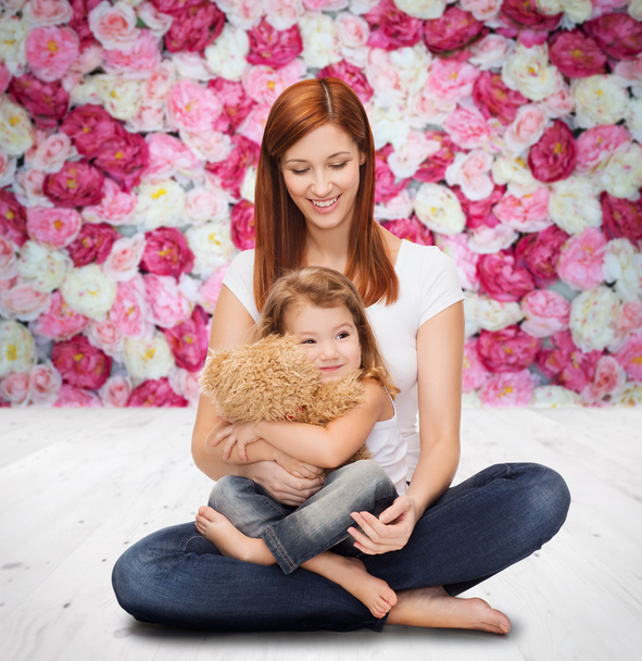 Happy mother with adorable girl and teddy bear - Photo, image