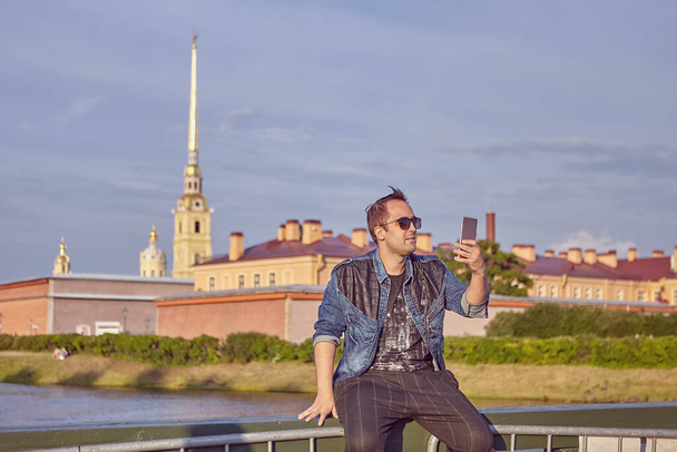 Male tourist with phone in Saint-Petersburg, Russia. - Zdjęcie, obraz