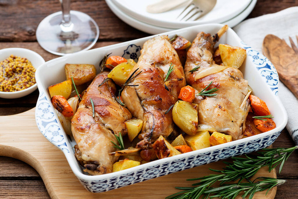 Stewed in white wine with spices rabbit legs with baked vegetables and rosemary. - Photo, Image