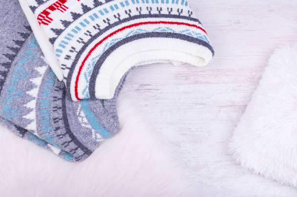 Теплые зимние вязаные свитера на белом уютном фоне. - Фото, изображение