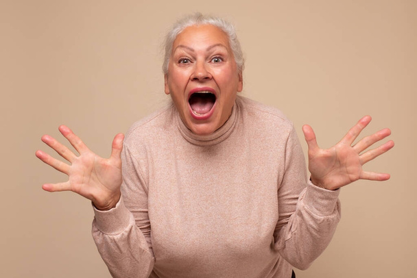 Senior caucasian woman is happy and shows ten fingers. Studio shot - Photo, Image
