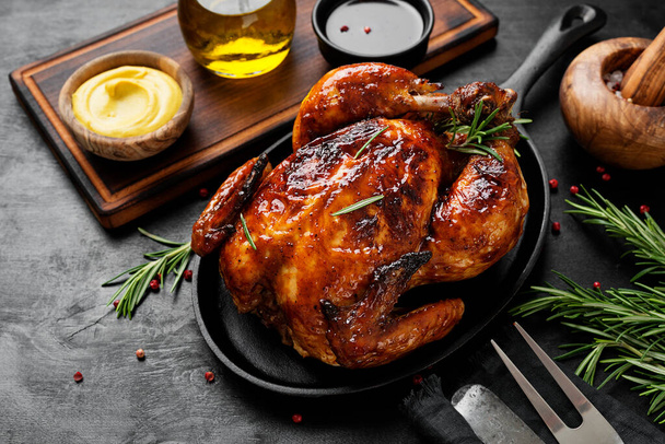 Domácí pečené kuře s rozmarýnem podávané v železné pánvi s omáčkou. - Fotografie, Obrázek