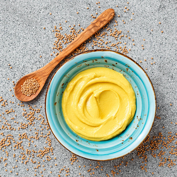 Delicious organic mustard sauce in bowl with wooden spoon.		 - Foto, Imagem