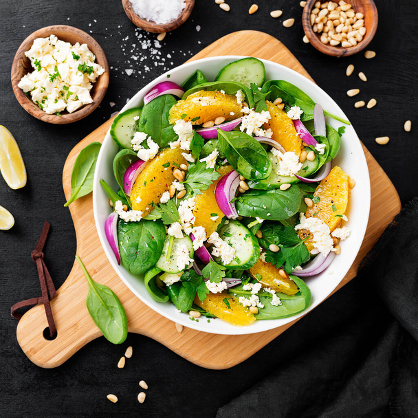 Fresh spinach salad with oranges, feta (ricotta) cheese, red onion and pine nuts .	 - 写真・画像