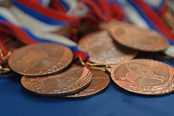 Bronze sports medals on a ribbon with a flag - Фото, зображення