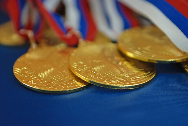 Gold sports medals on ribbon with flag - 写真・画像