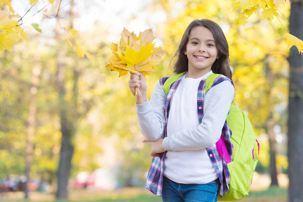 autumn kid fashion. romantic season for inspiration. happy childhood. back to school. teenage girl with backpack relax walking in park. fall season beauty. enjoy day in forest. autumn forest - Фото, зображення