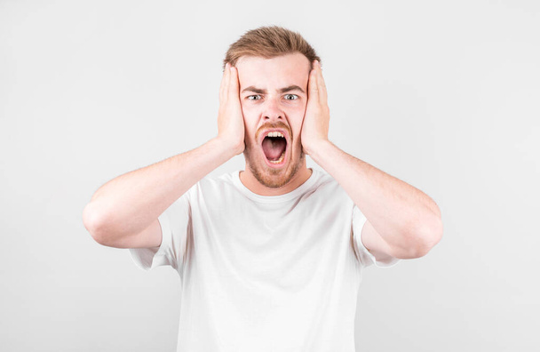 Portrait of young screaming guy , isolated on white studio background - Fotó, kép