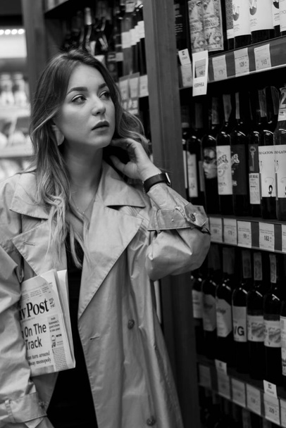 seksikäs houkutteleva nainen viinikaupassa keskuudessa hyllyt viiniä. mustavalkoinen valokuva. pehmeä fokus - Valokuva, kuva