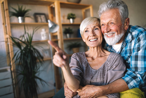 Happy smiling senior couple in love hugging and bonding with true emotions at home - Фото, изображение