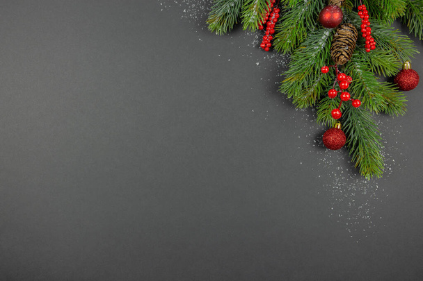 Decoraciones rojas festivas de Navidad, ramas de abeto con nieve sobre fondo oscuro. Acostado. Vista superior. Copiar espacio. Composición de la plantilla. - Foto, imagen
