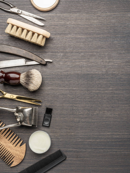 Классический груминг и парикмахерские инструменты на деревянном фоне. Вид сверху на инструменты парикмахерской, лежащие на темном деревянном столе. - Фото, изображение