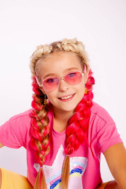 κορίτσι σε φωτεινά πολύχρωμα ρούχα και με χρωματιστές πλεξούδες - Φωτογραφία, εικόνα