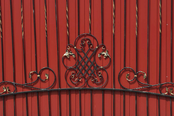 černá červená textura kovových kovaných tyčí ve vzoru na kovové stěně plotu - Fotografie, Obrázek