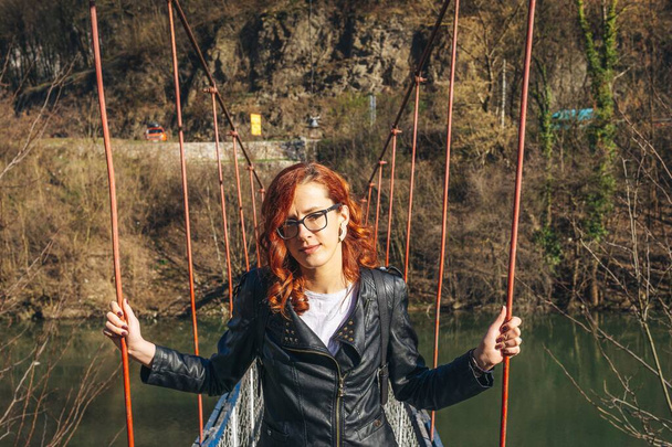 Young woman posing on an old cable bridge - Photo, Image