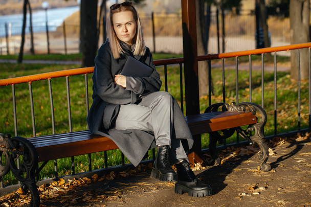 美しい白い女の子30歳公共公園に座って、ラップトップを見て - 写真・画像
