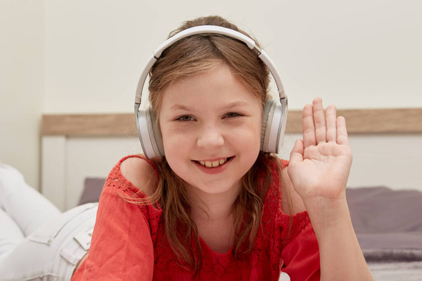 Young beautiful girl in big white headphones, smiling and looking at the camera. - Foto, Imagen