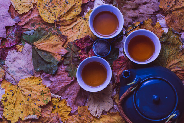autumn still life with tea cups, teapot and fall leaves  - Fotó, kép