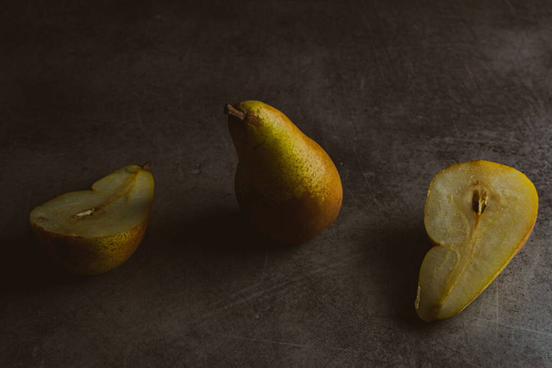 close-up view of fresh ripe pears on dark surface - Fotoğraf, Görsel