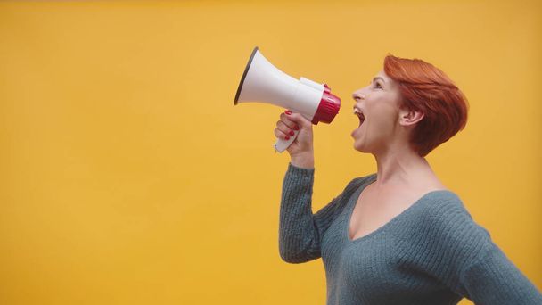 roodharige vrouw in de 40 spreekt in luidspreker - Foto, afbeelding