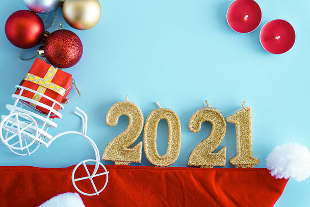Xmas, winter, new year concept - layout white plate on which there are three Christmas trees cut from sausage cheese bread with santa hat and golden candles in form of numbers 2021 Blue background - Photo, image