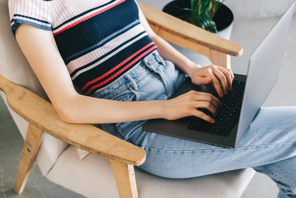 Woman using laptop computer and typing on keyboard. Freelancer working distantly at home. High quality photo - Foto, Bild