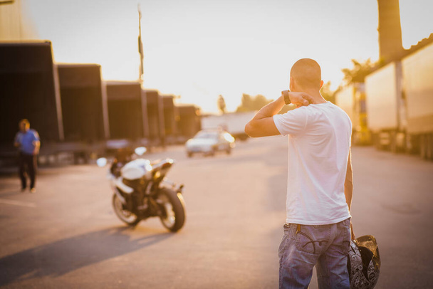 A young guy and a powerful sports bike. Photo on the street. - Zdjęcie, obraz