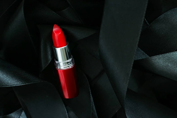 Czerwona szminka na czarnym jedwabnym tle, luksusowy makijaż i kosmetyka - Zdjęcie, obraz