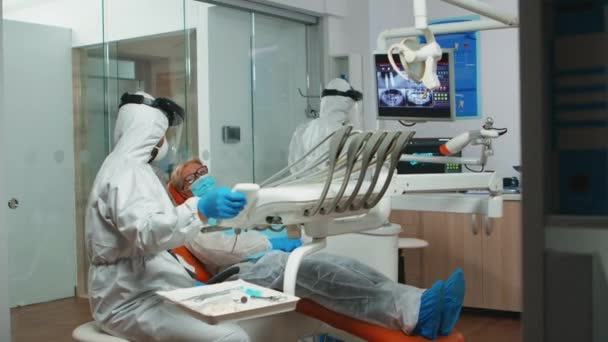 Tecnico dentista in tuta preparazione per la chirurgia dentale - Filmati, video