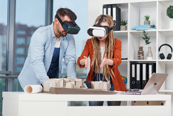 Group of young architects at VR goggles working with mock-up of a house in modern office. - Φωτογραφία, εικόνα