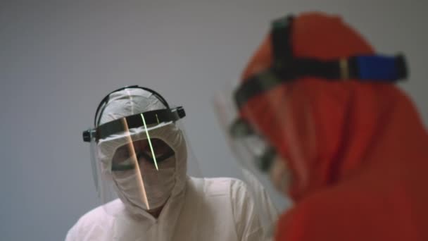 Lääkärit suojapuvuissa kuulla Coronavirus potilaiden tila - Materiaali, video