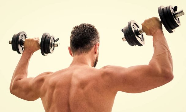 Sportsman with strong back and arms. Sport equipment. Bodybuilding sport. Sport lifestyle. Dumbbell exercise gym. Muscular man exercising with dumbbell rear view. Actions speak louder than coaches - Photo, Image