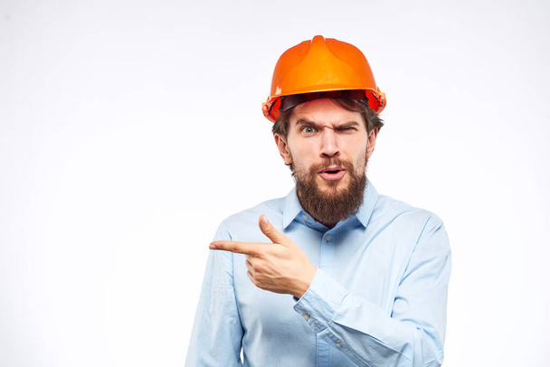 Homme en chemise orange casque sécurité émotions construction professionnel recadré vue - Photo, image